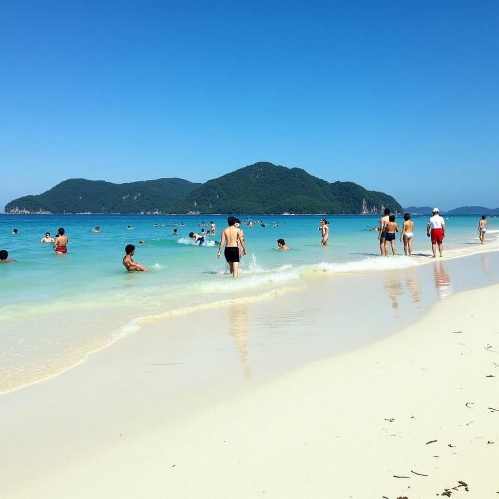 Du khách tắm biển và vui chơi trên bãi biển cát trắng mịn tại đảo Hòn Chuông, Đắk Lắk.